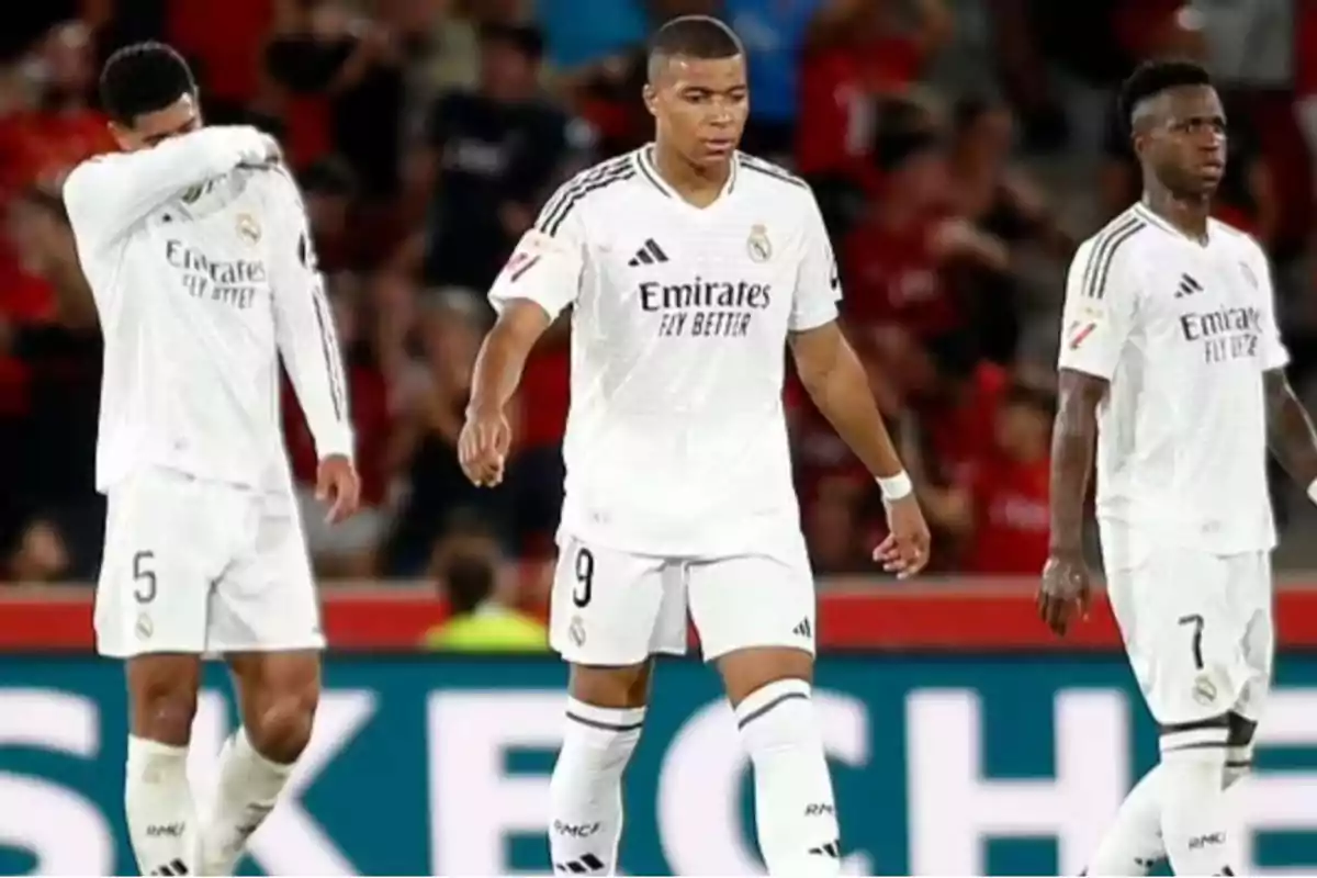 Real Madrid soccer players on the field in white uniforms during a match.