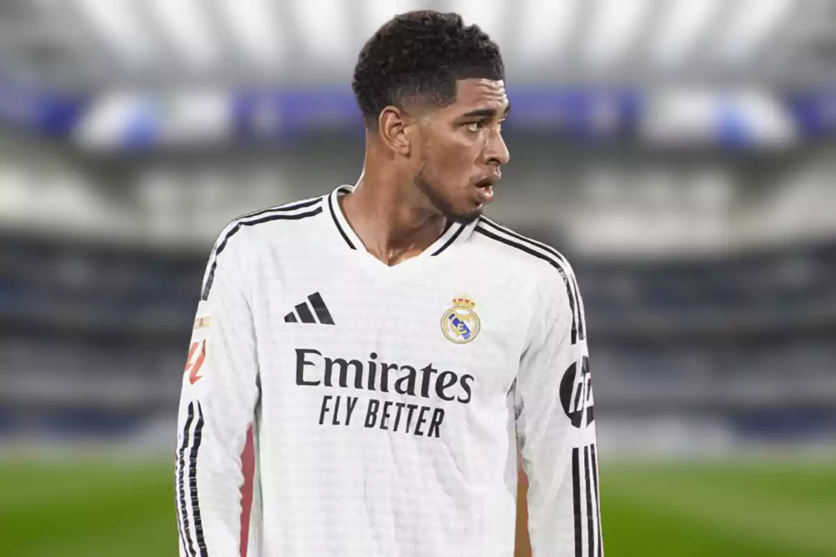 Un jugador de fútbol con la camiseta blanca del Real Madrid en un estadio.