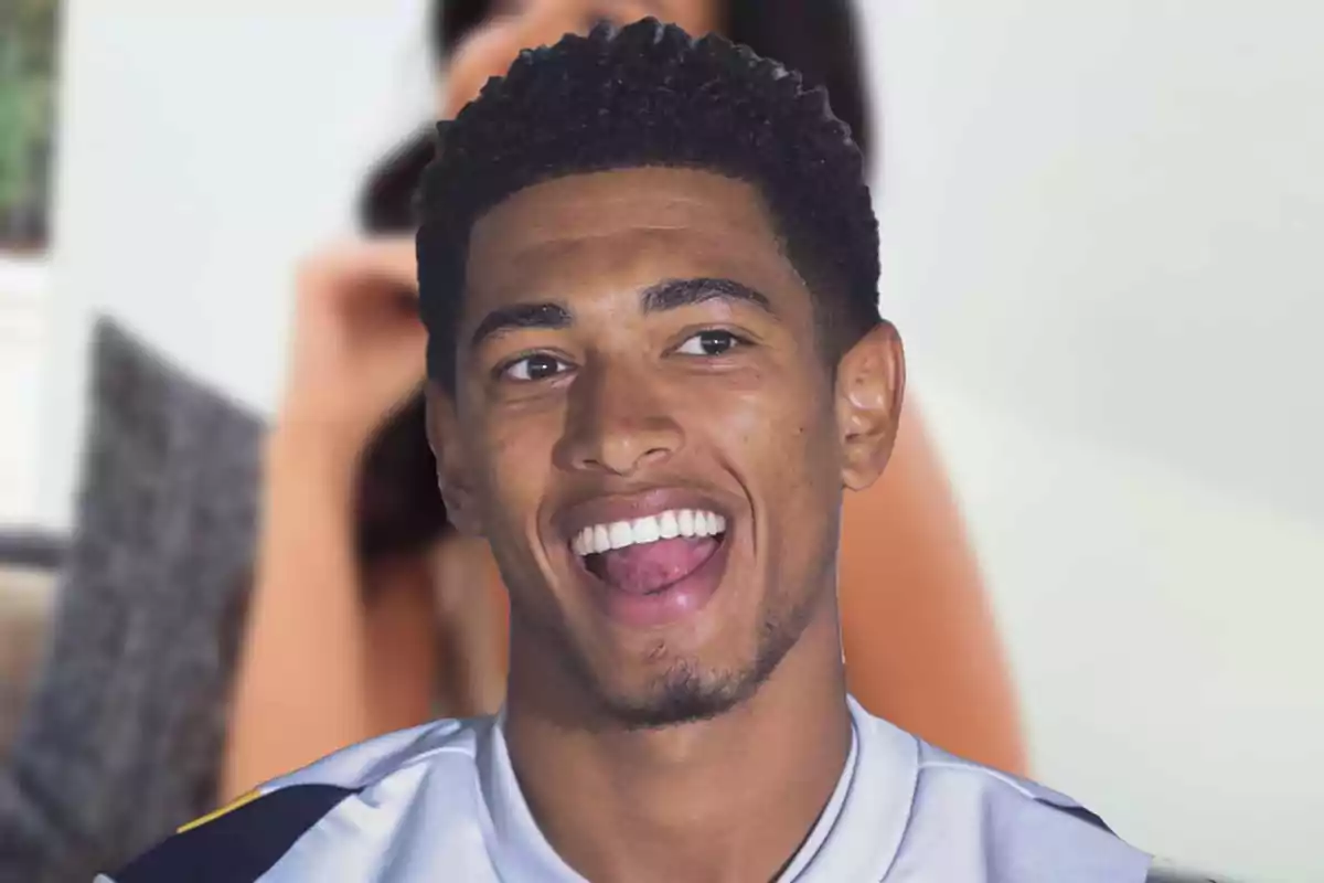 Un hombre sonriente con una camiseta deportiva.