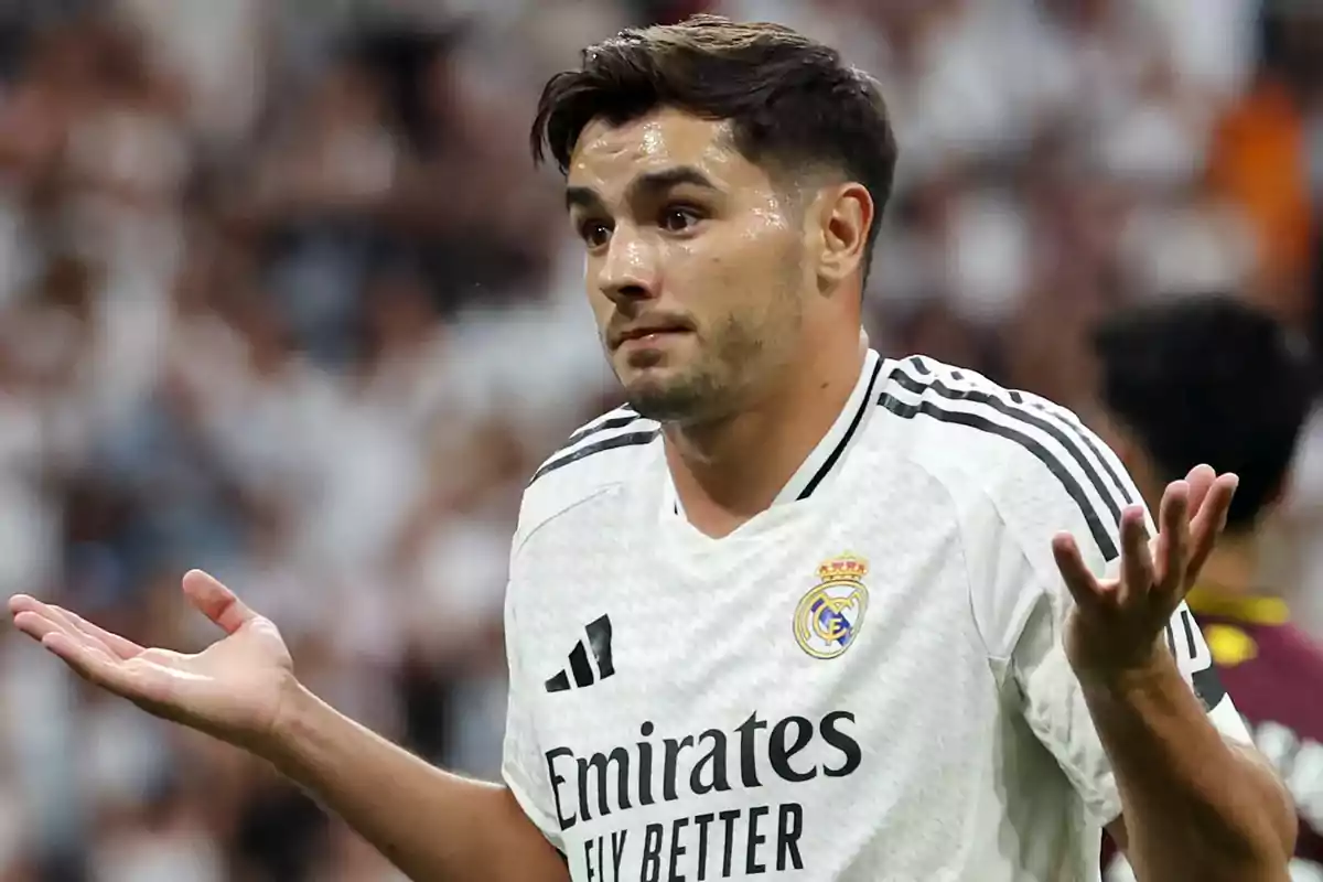 A soccer player in a Real Madrid uniform raises his hands in a gesture of confusion during a match. A soccer player in a Real Madrid uniform raises his hands in a gesture of confusion during a match.