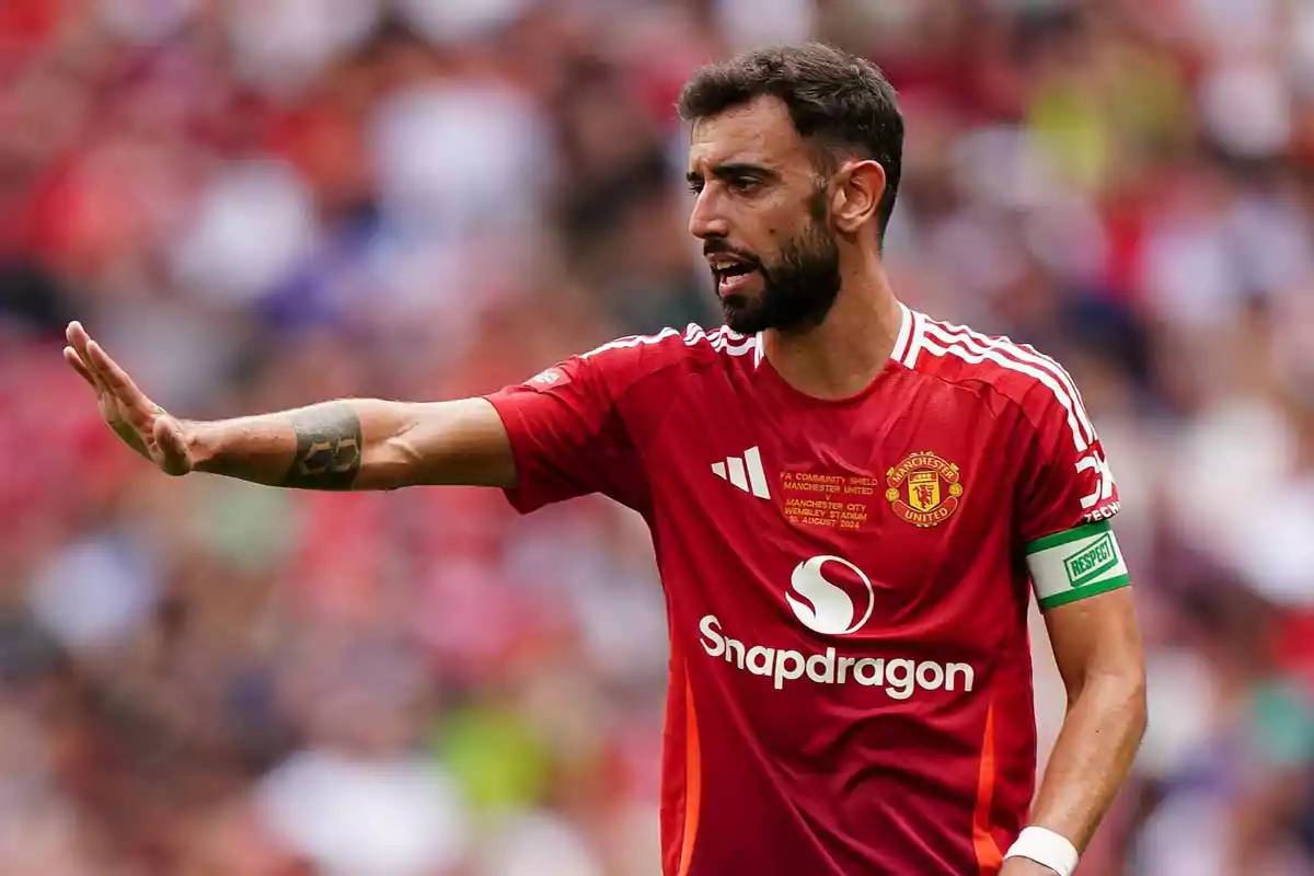 Jugador de fútbol con uniforme rojo gesticulando en el campo durante un partido. Jugador de fútbol con uniforme rojo gesticulando en el campo durante un partido.