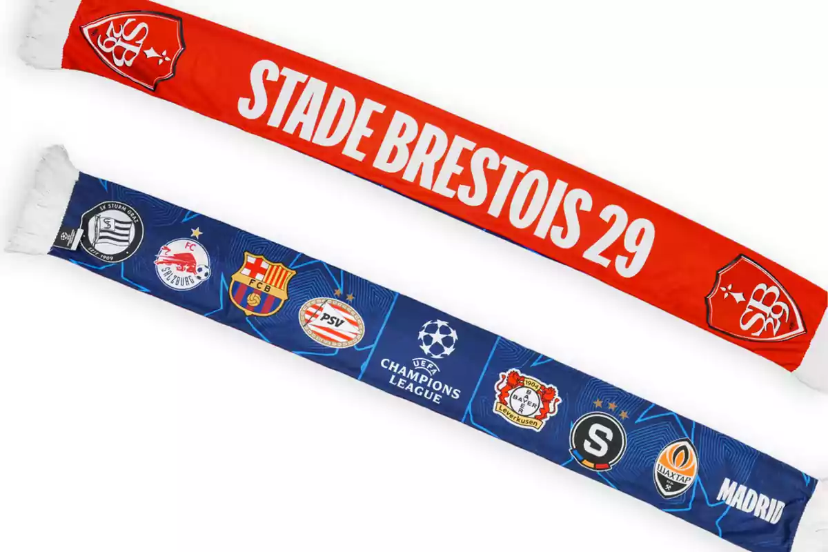 Dos bufandas de fútbol, una roja con el texto "Stade Brestois 29" y otra azul con logotipos de varios equipos y el emblema de la UEFA Champions League.