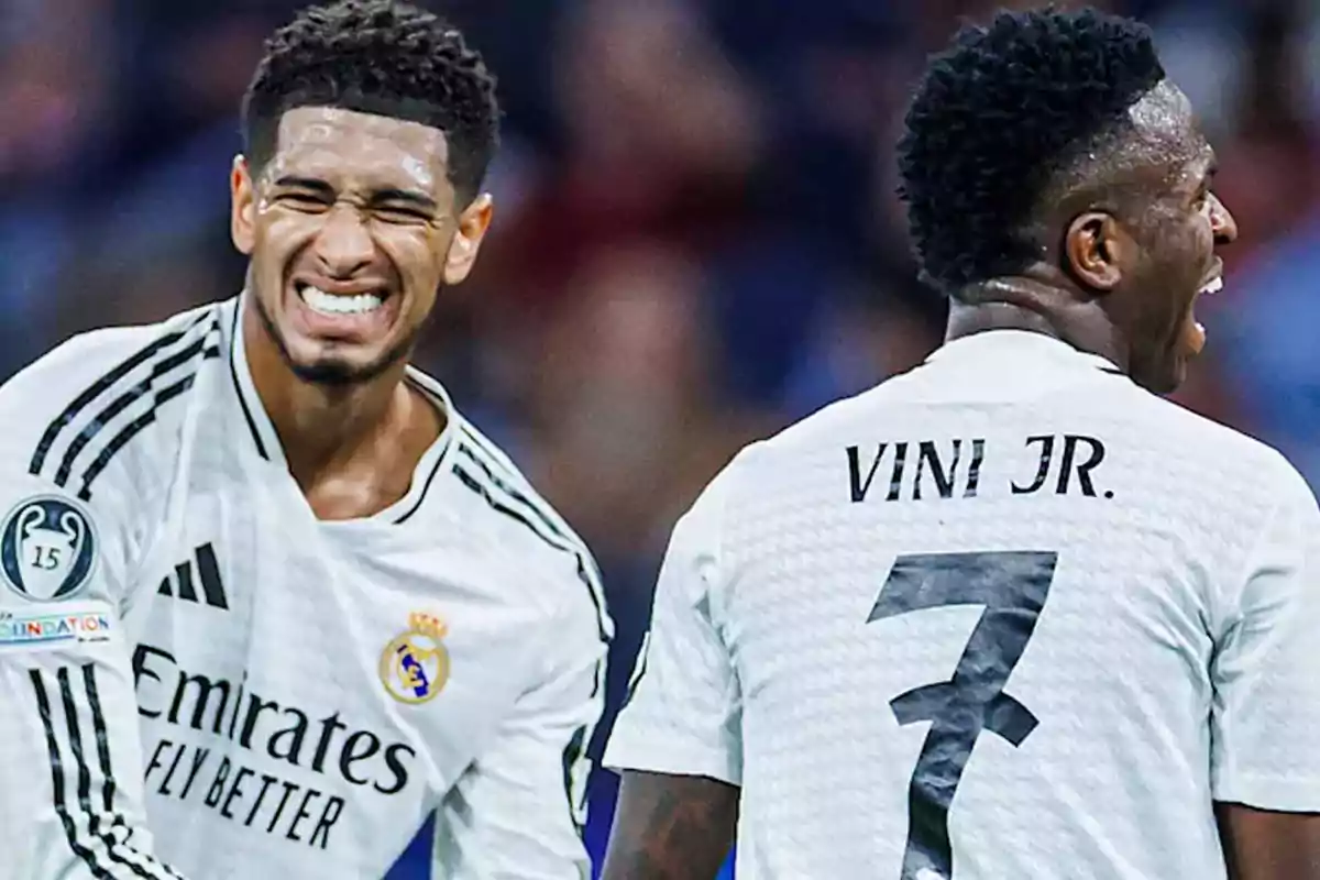 Dos jugadores de fútbol del Real Madrid celebran en el campo durante un partido.