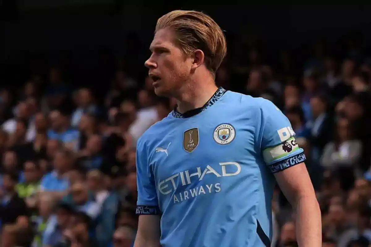 Soccer player in a light blue Manchester City jersey in a stadium full of spectators. Soccer player in a light blue Manchester City jersey in a stadium full of spectators.