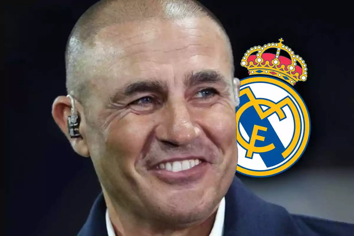 Un hombre sonriente con un auricular y el escudo del Real Madrid de fondo.