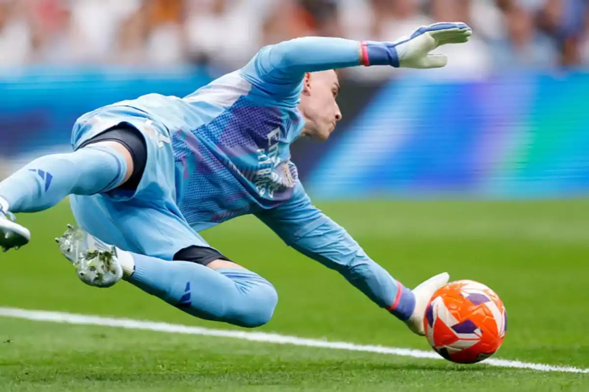 Portero de fútbol realizando una atajada en pleno vuelo durante un partido. Portero de fútbol realizando una atajada en pleno vuelo durante un partido.