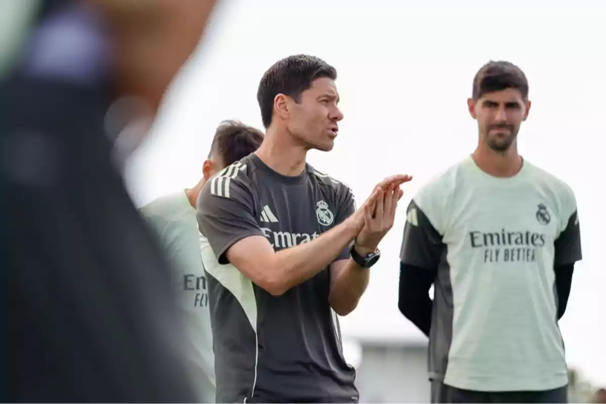 Real Madrid coach giving instructions to his players during an outdoor training session Real Madrid coach giving instructions to his players during an outdoor training session