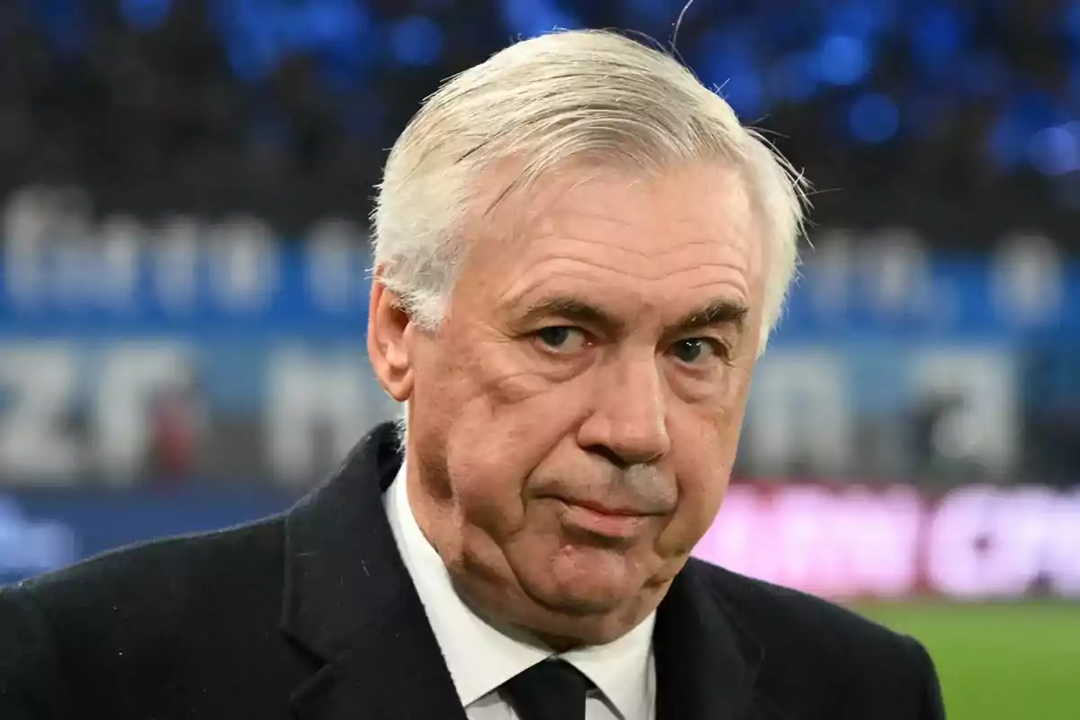 A man with gray hair and a serious expression in a sports environment. A man with gray hair and a serious expression in a sports environment.