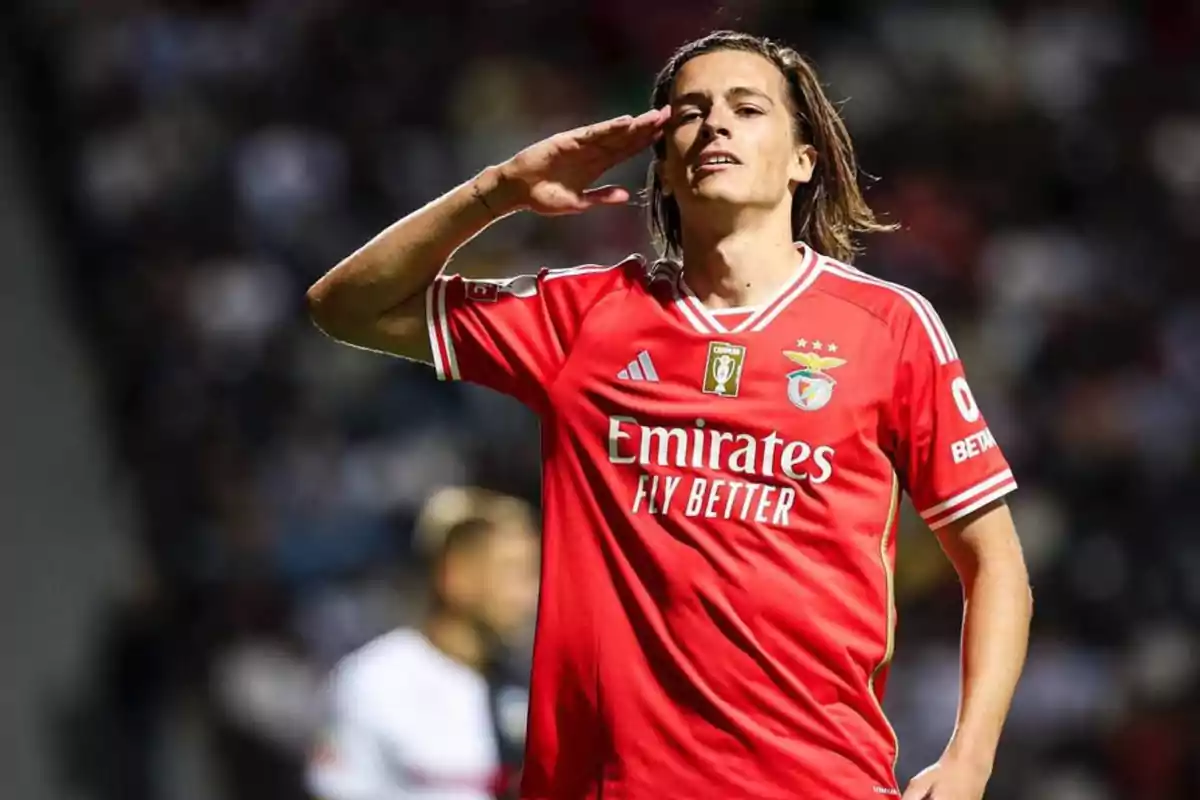 Futbolista con uniforme rojo del Benfica haciendo un gesto de saludo militar durante un partido Futbolista con uniforme rojo del Benfica haciendo un gesto de saludo militar durante un partido