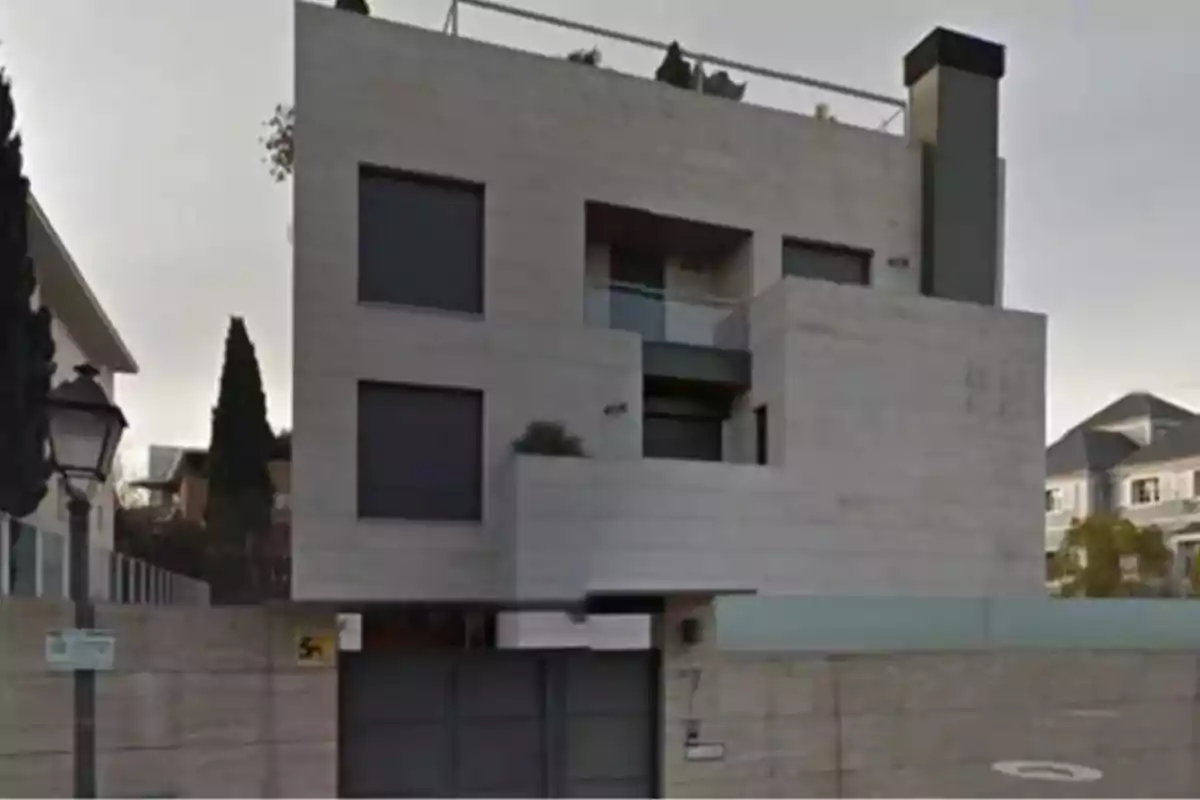 Edificio moderno de tres pisos con fachada de piedra y ventanas oscuras. Edificio moderno de tres pisos con fachada de piedra y ventanas oscuras.