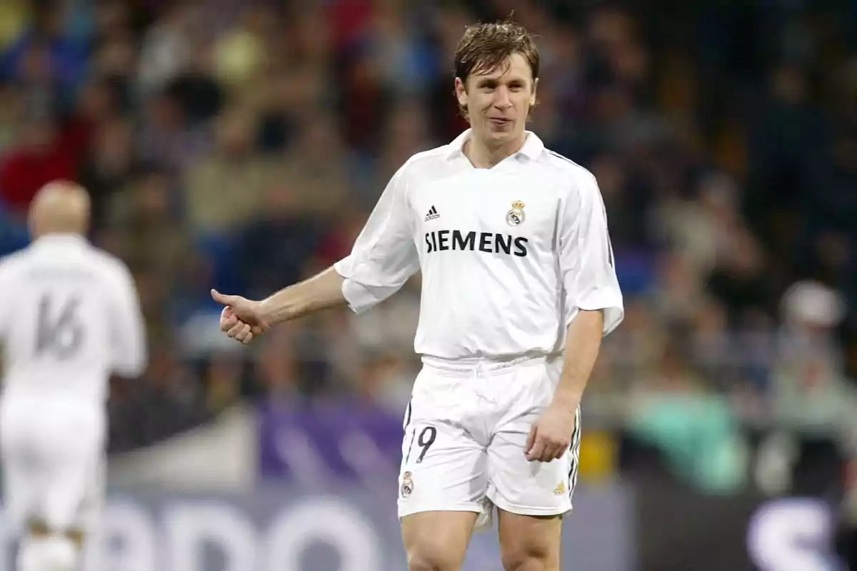 A soccer player in the white uniform of Real Madrid on the field during a match. A soccer player in the white uniform of Real Madrid on the field during a match.
