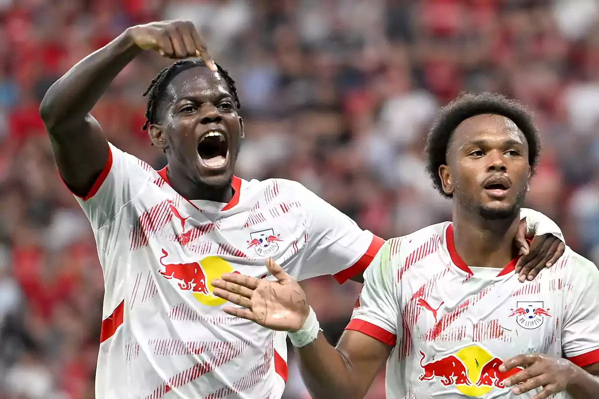 Two RB Leipzig soccer players celebrate a goal on the field. Two RB Leipzig soccer players celebrate a goal on the field.
