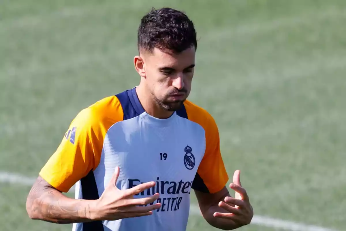 Un jugador de fútbol con uniforme de entrenamiento del Real Madrid en el campo.