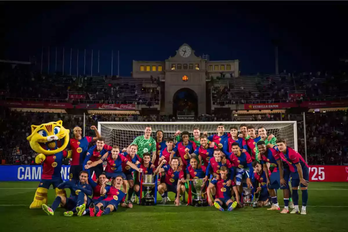 A soccer team celebrates with trophies in front of a goal in a stadium lit up at night. A soccer team celebrates with trophies in front of a goal in a stadium lit up at night.
