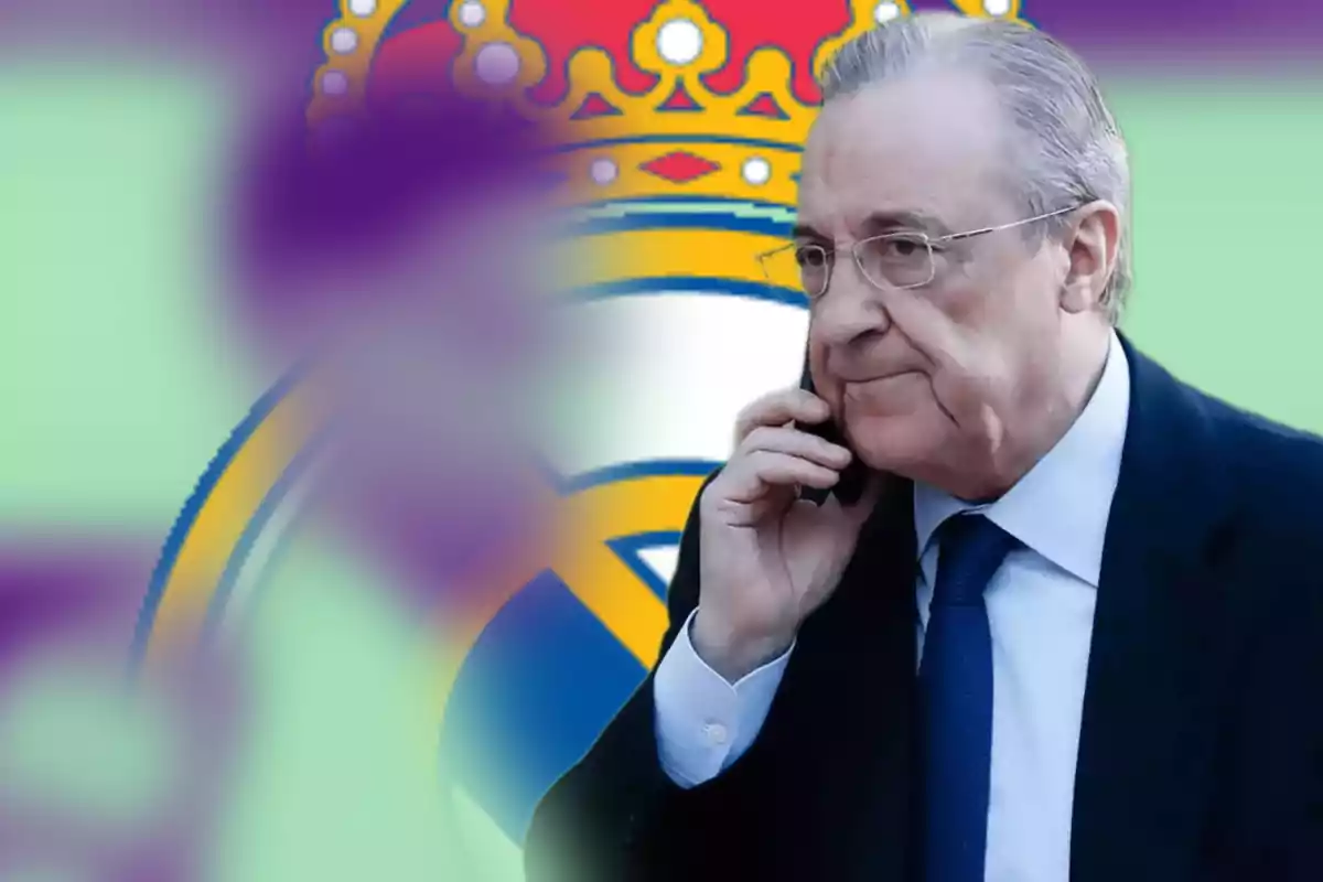 Un hombre hablando por teléfono con un fondo que incluye un escudo deportivo.