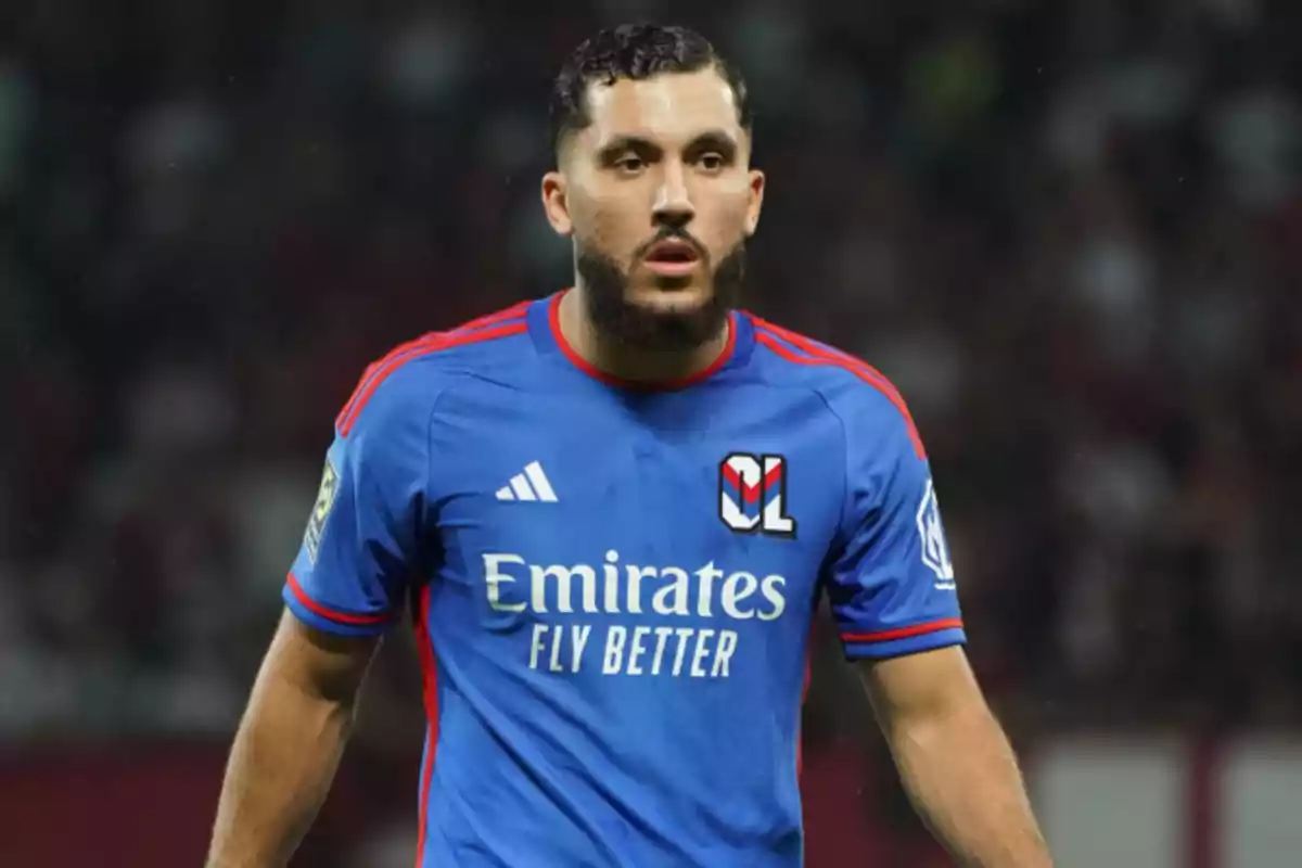 Jugador de fútbol con uniforme azul del Olympique de Lyon durante un partido. Jugador de fútbol con uniforme azul del Olympique de Lyon durante un partido.