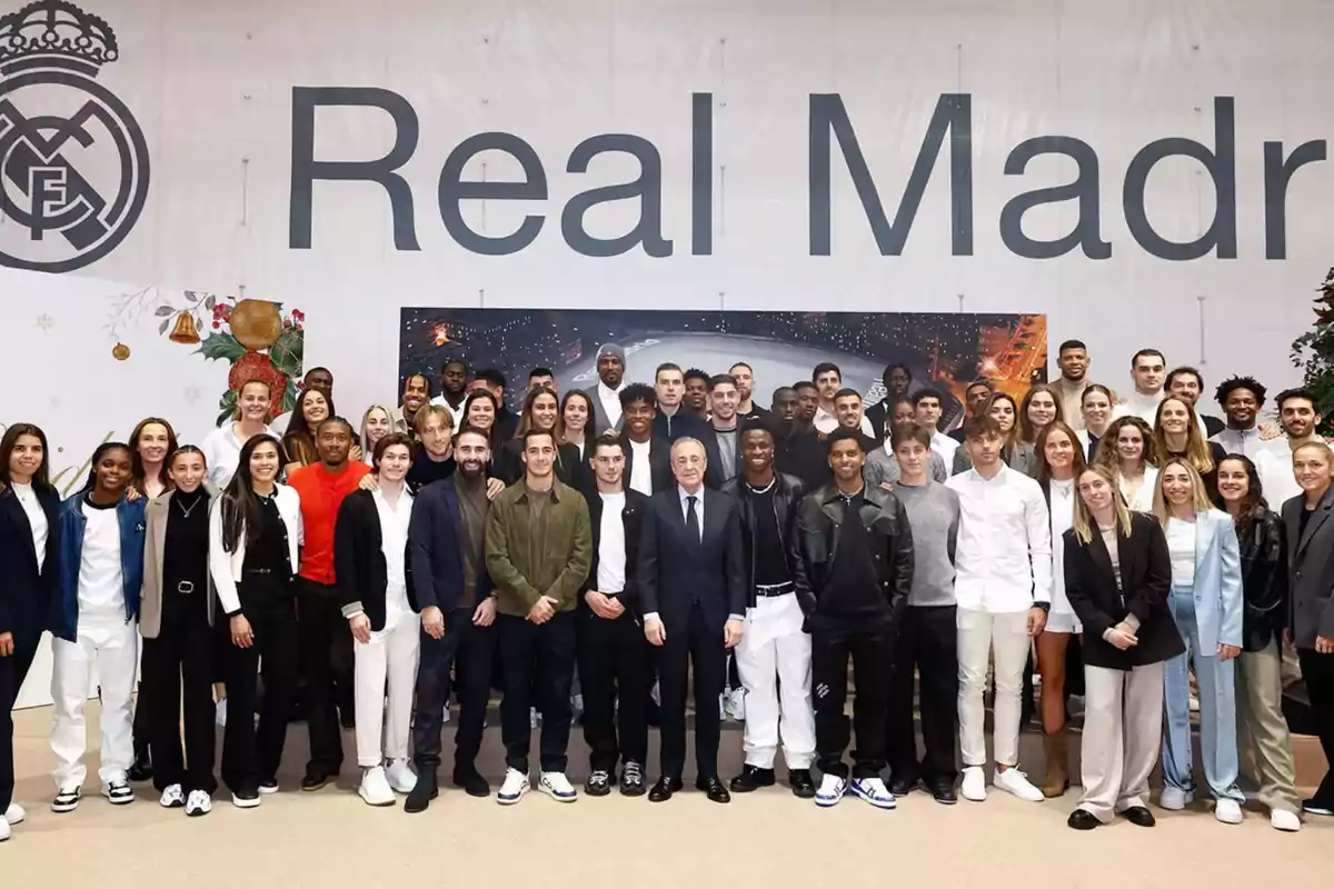 A group of people posing in front of a sign that says A group of people posing in front of a sign that says