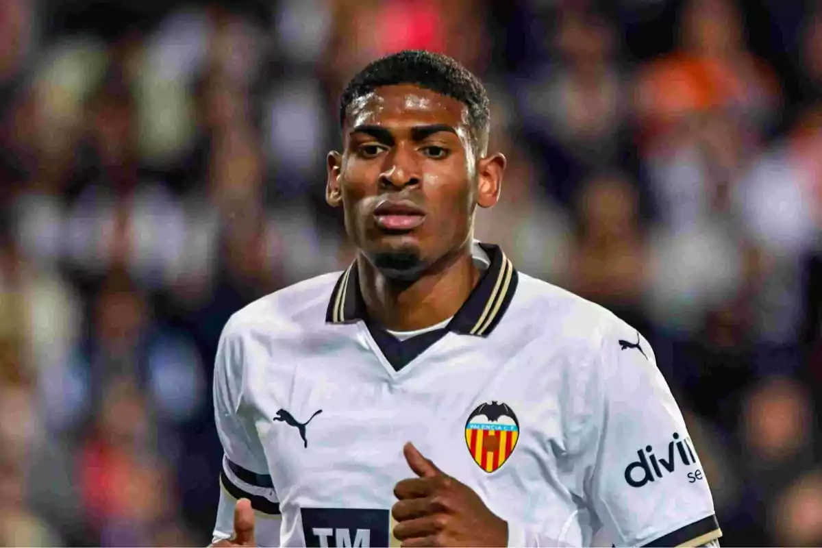 Jugador de fútbol con uniforme del Valencia CF en el campo de juego.