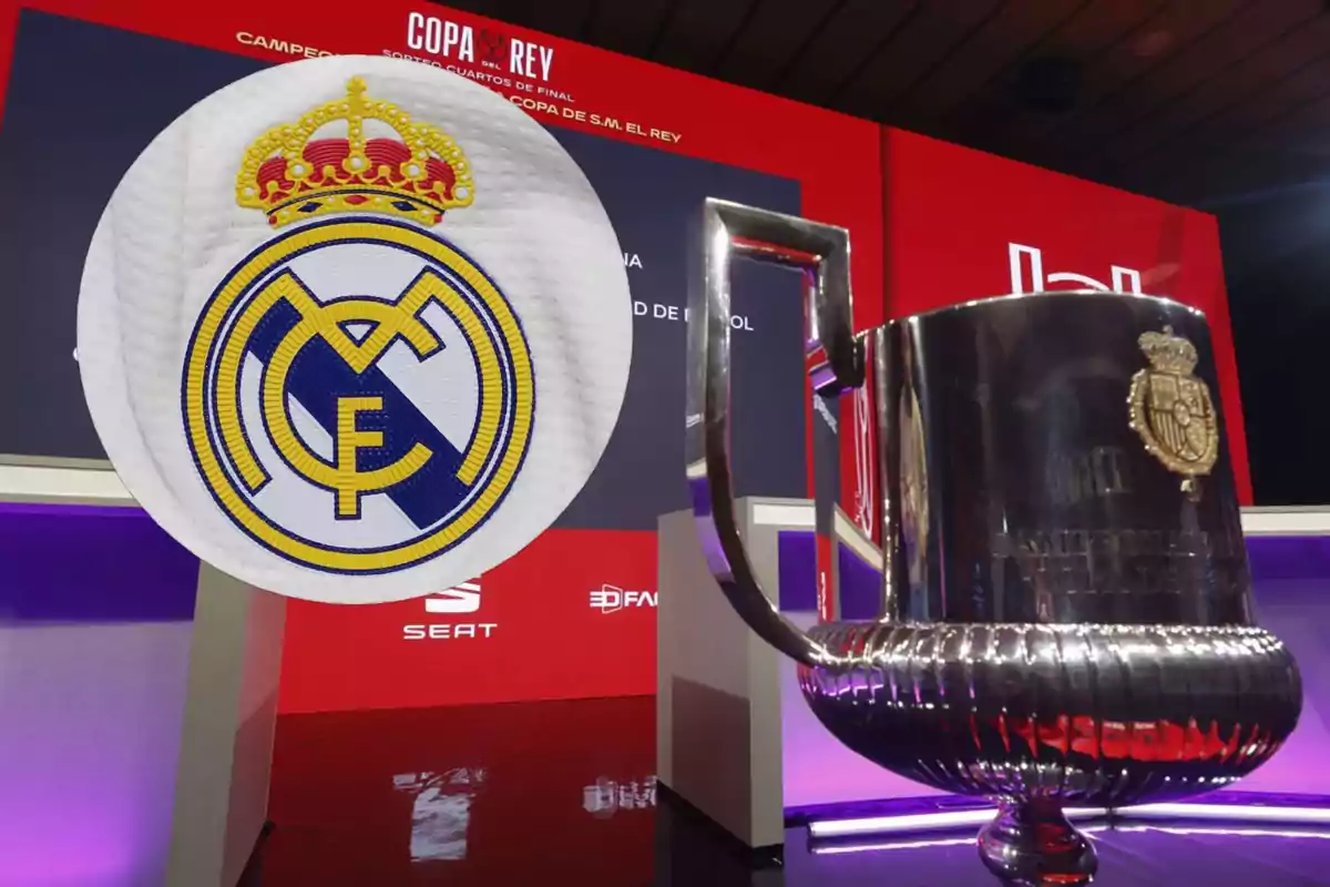 A soccer team's crest next to a Copa del Rey trophy on a stage.