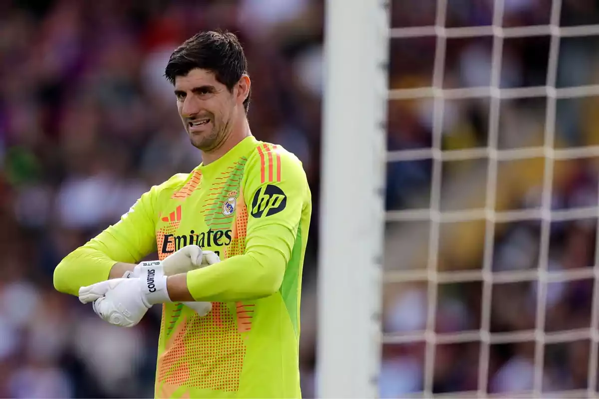 Real Madrid goalkeeper in a fluorescent yellow uniform adjusting his gloves in front of the goal during a soccer match Real Madrid goalkeeper in a fluorescent yellow uniform adjusting his gloves in front of the goal during a soccer match