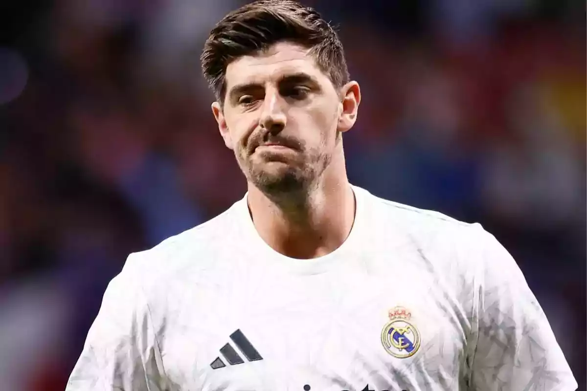 A soccer player in a white Real Madrid uniform on the field. A soccer player in a white Real Madrid uniform on the field.