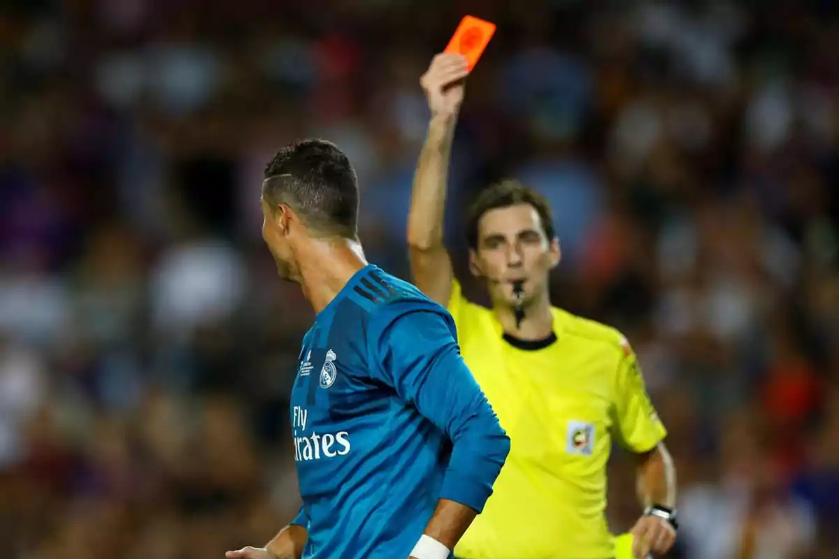 A referee shows a red card to a player during a match.