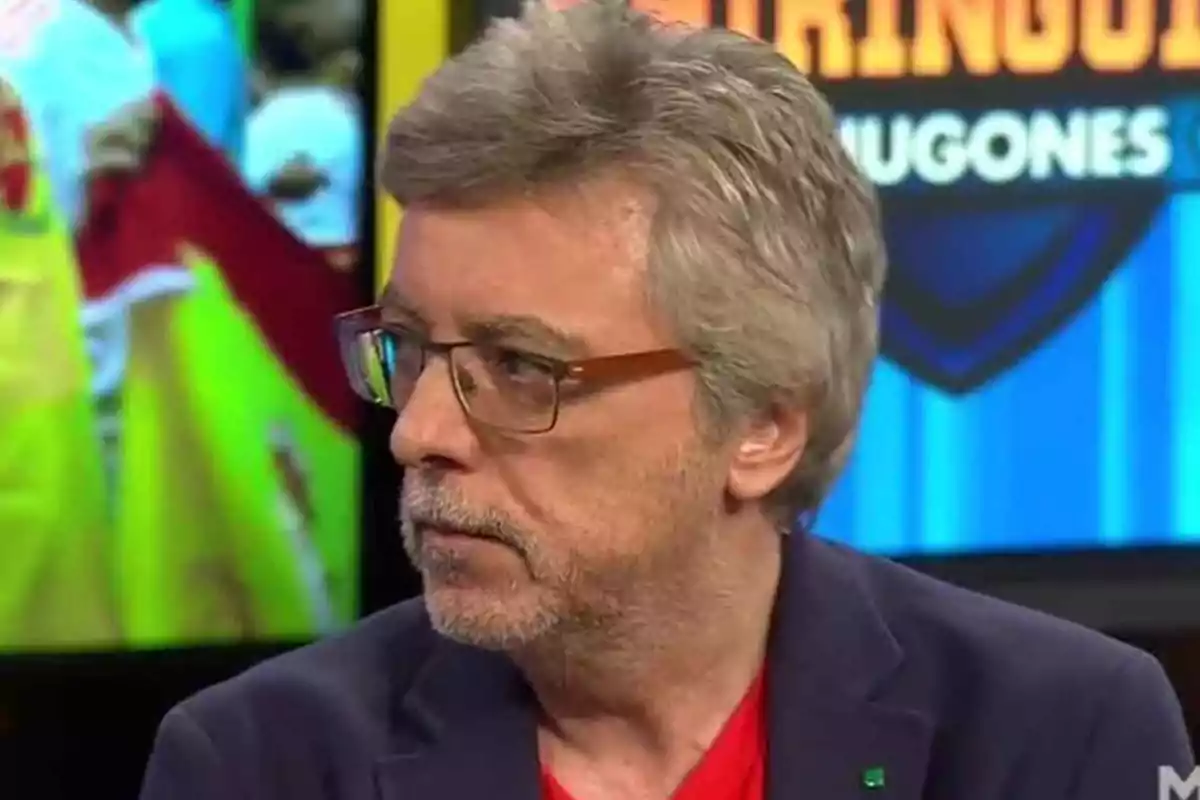 A man with glasses and gray hair in a television studio. A man with glasses and gray hair in a television studio.