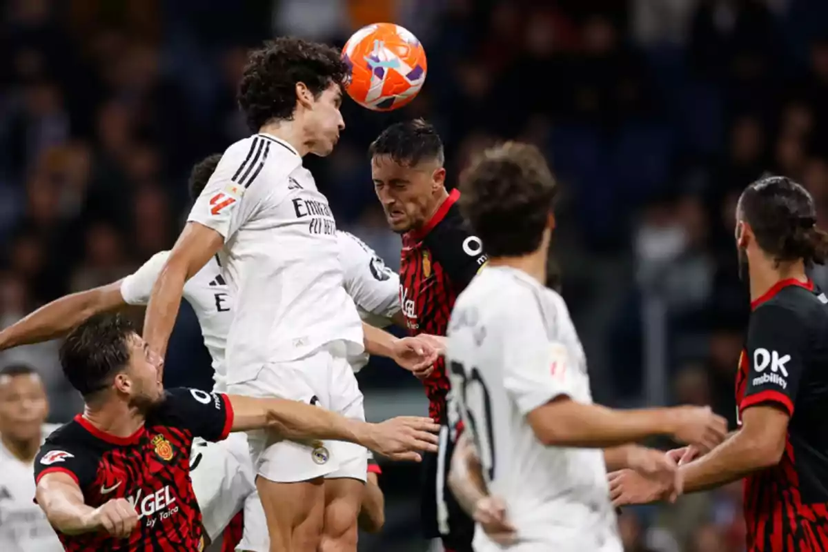 Soccer players compete for a ball in the air during a match.