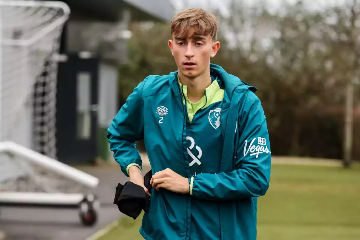 A young man in a blue sports jacket with the number 2 on his chest is on a training field. A young man in a blue sports jacket with the number 2 on his chest is on a training field.