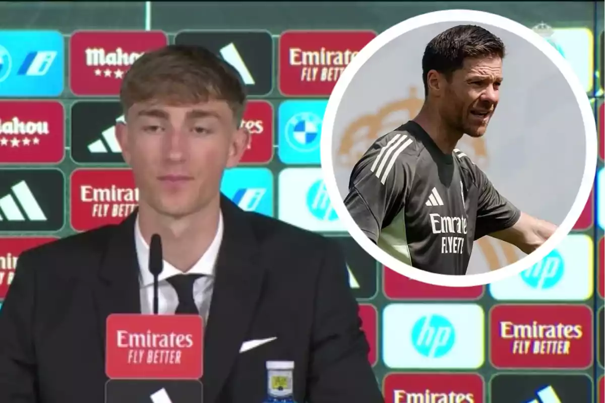 Un joven con traje habla en una conferencia de prensa con un fondo de patrocinadores y en la esquina superior derecha aparece la imagen de un entrenador con ropa deportiva