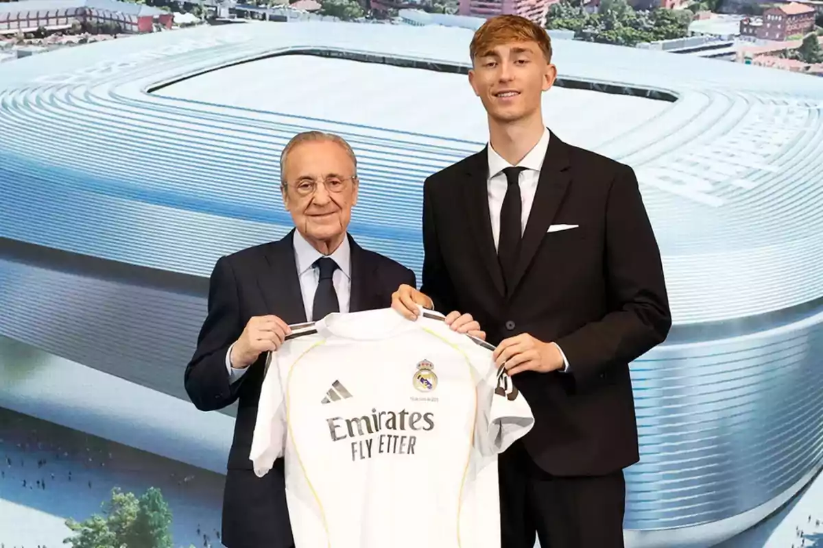 Dos hombres con traje sostienen una camiseta del Real Madrid frente a una imagen del estadio Santiago Bernabéu. Dos hombres con traje sostienen una camiseta del Real Madrid frente a una imagen del estadio Santiago Bernabéu.