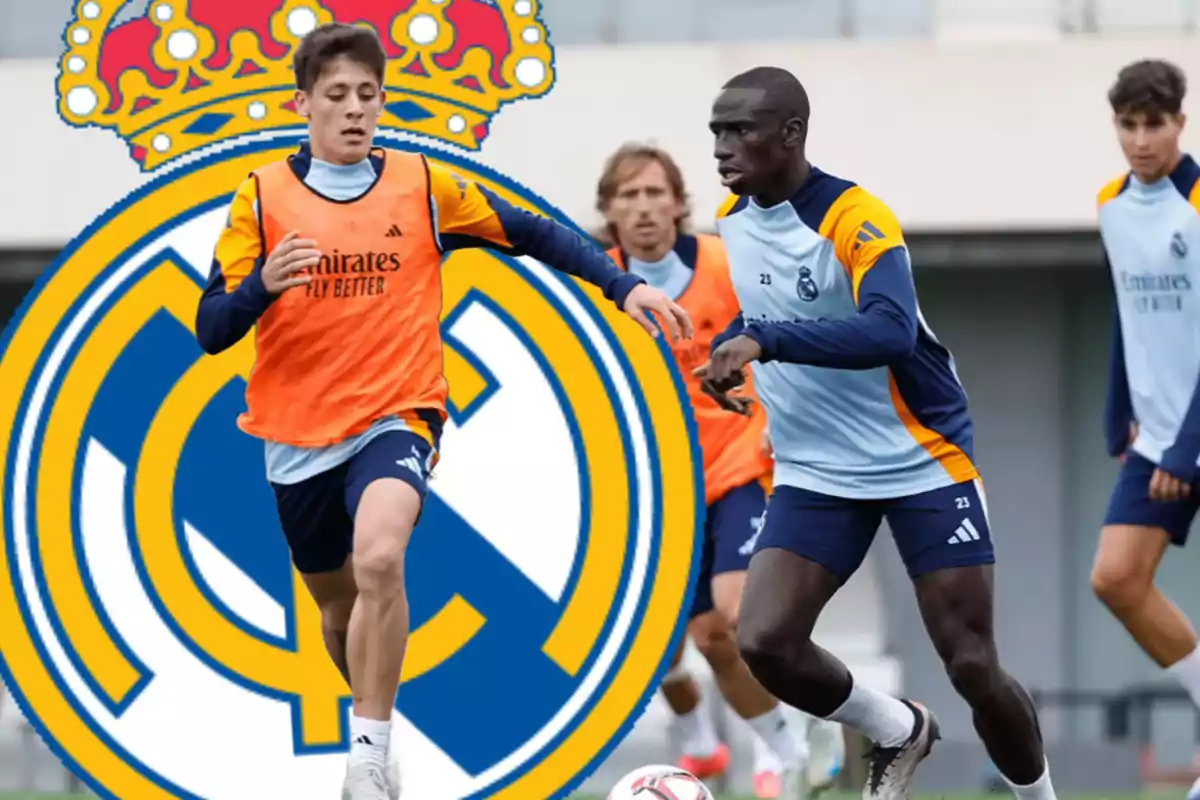 Soccer players training with the Real Madrid crest in the background.