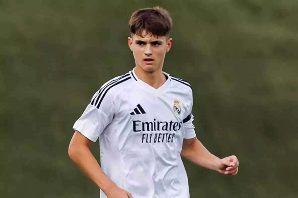 Un jugador de fútbol con uniforme blanco en el campo. Un jugador de fútbol con uniforme blanco en el campo.