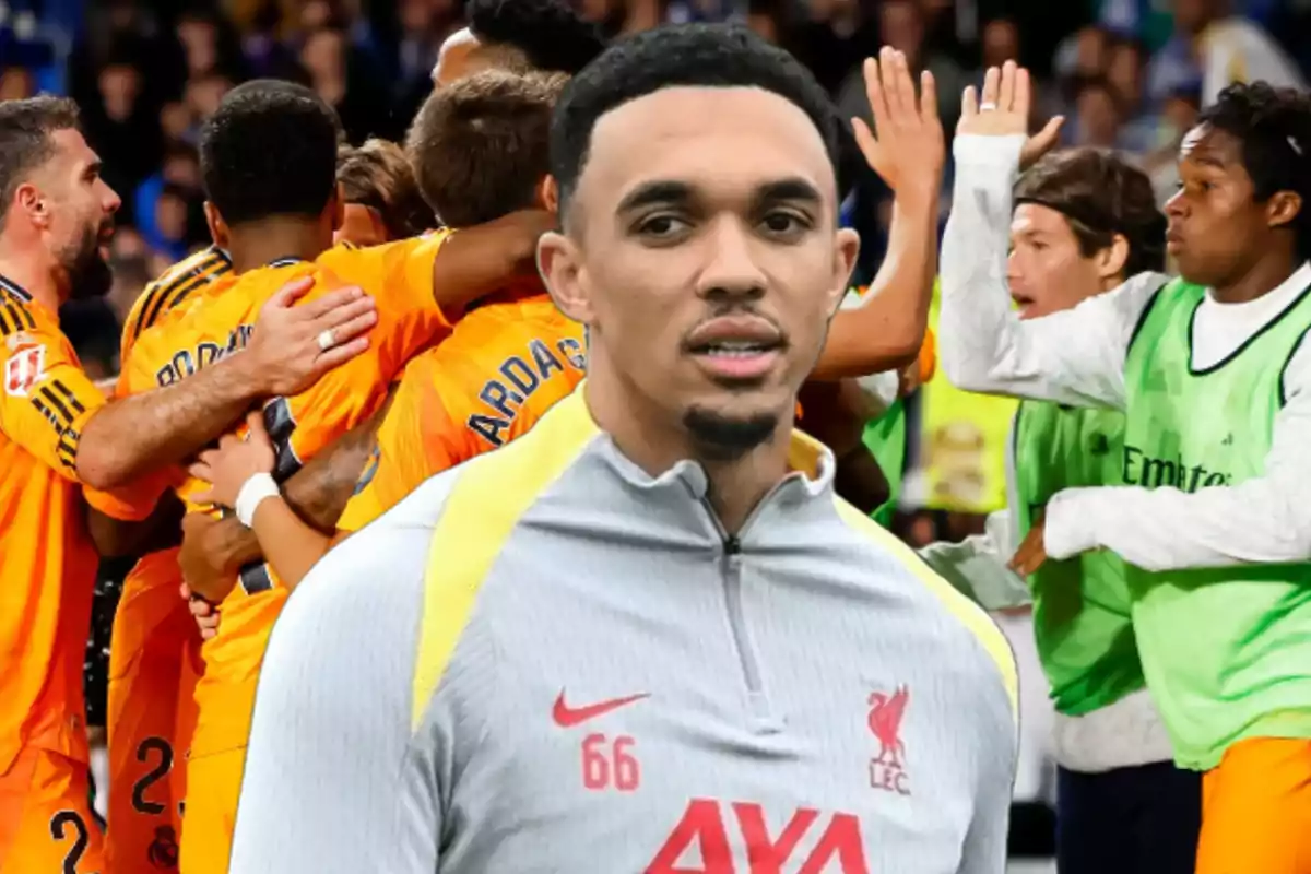 Un jugador de fútbol con uniforme de entrenamiento del Liverpool está en primer plano mientras un grupo de jugadores celebra en el fondo.