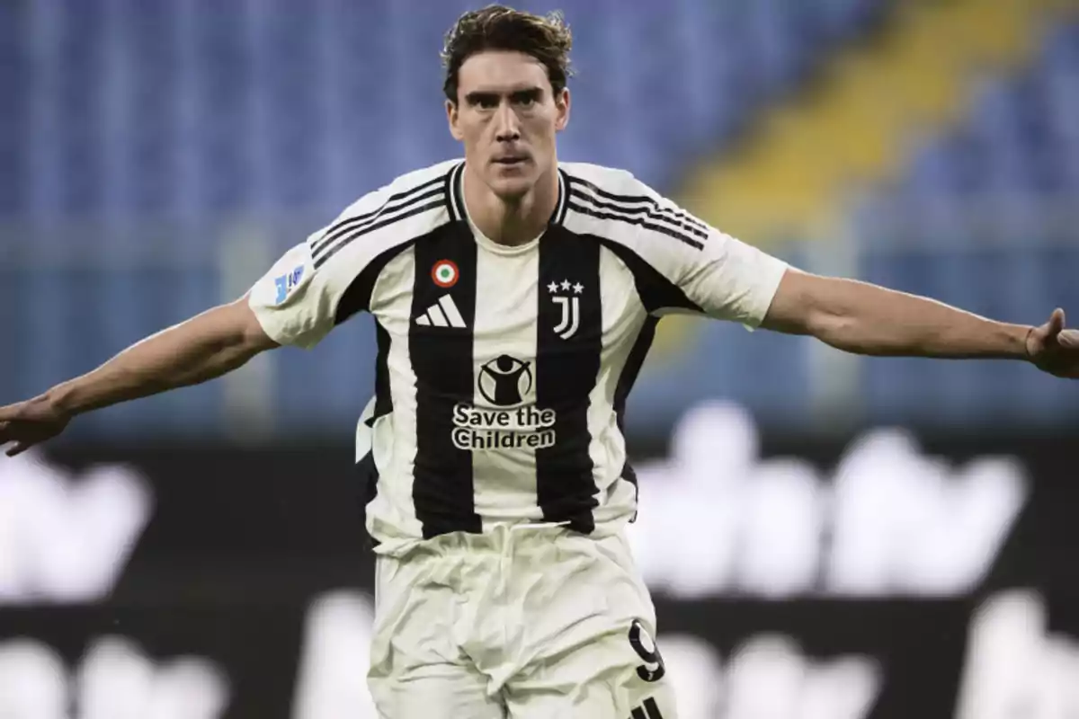 Soccer player in a Juventus uniform celebrating with arms outstretched in a stadium Soccer player in a Juventus uniform celebrating with arms outstretched in a stadium