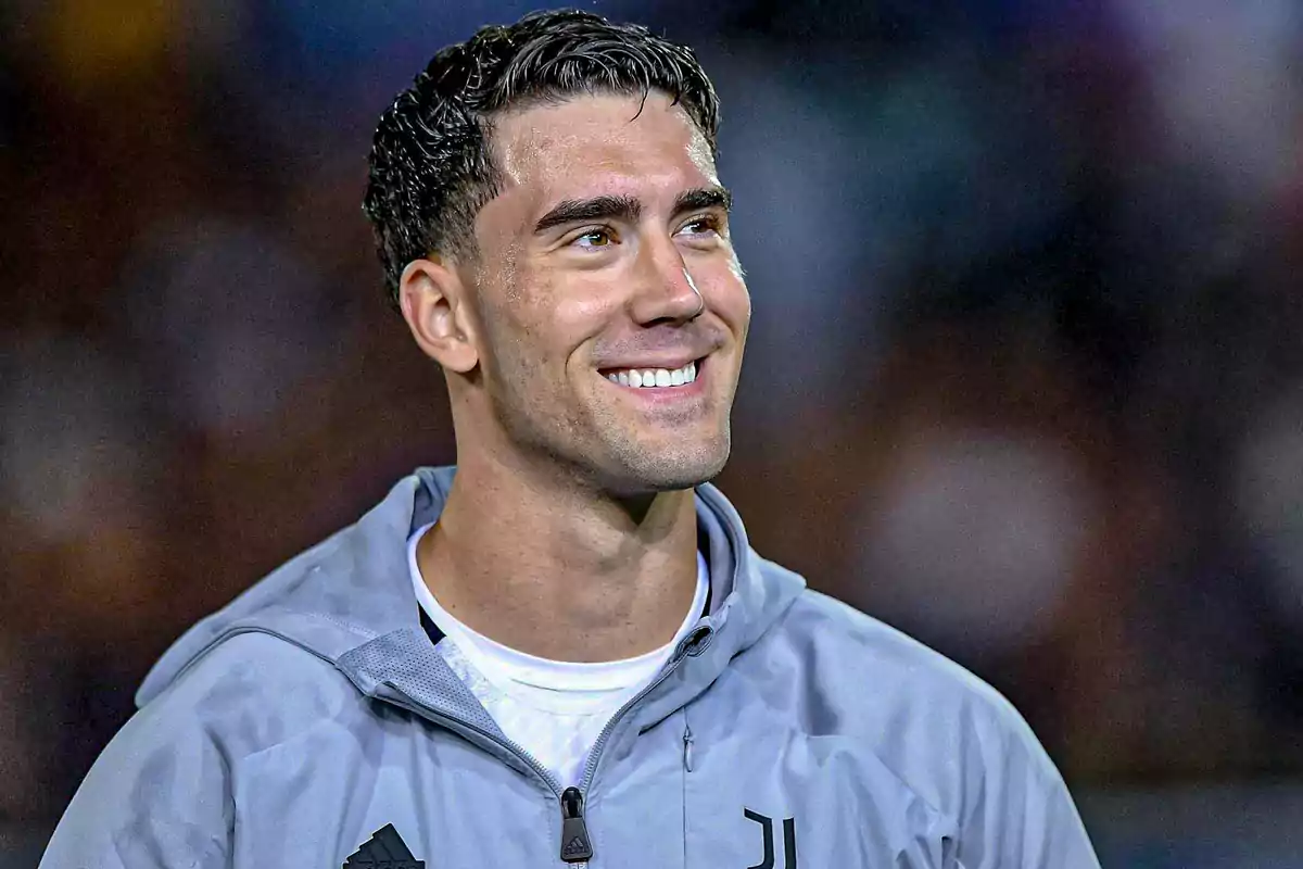 Young man in a gray sports jacket smiling in an outdoor setting Young man in a gray sports jacket smiling in an outdoor setting