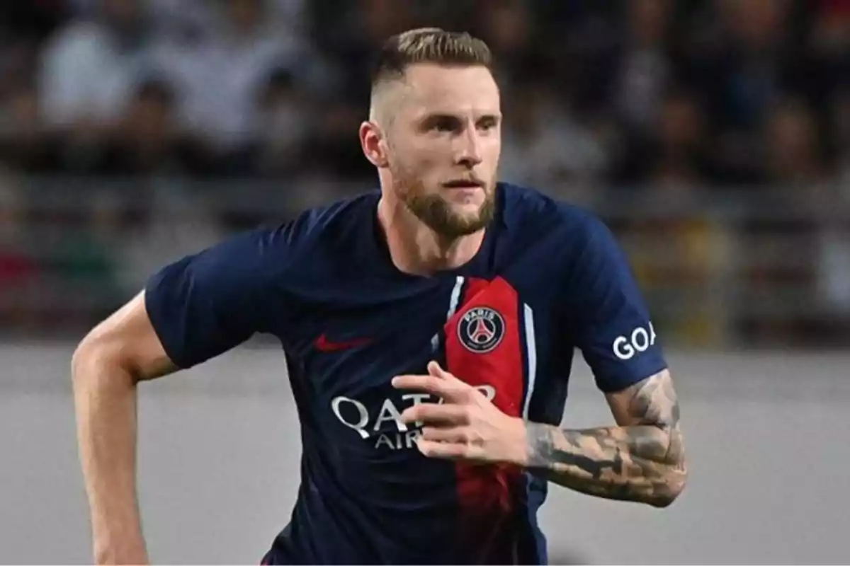 Football player in blue and red PSG uniform in action during a match. Football player in blue and red PSG uniform in action during a match.