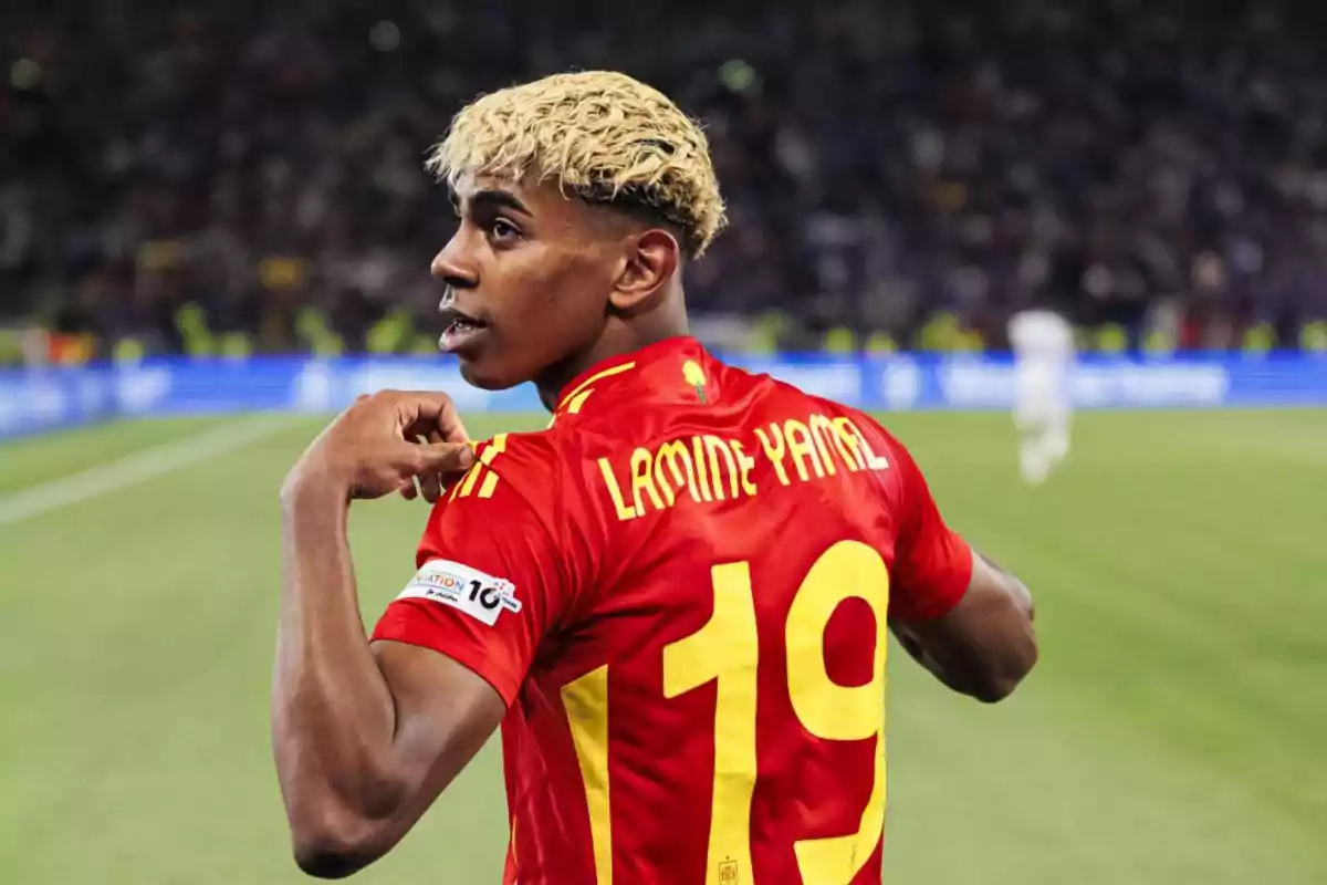 Jugador de fútbol con cabello rubio y camiseta roja número 19 celebrando en un estadio Jugador de fútbol con cabello rubio y camiseta roja número 19 celebrando en un estadio