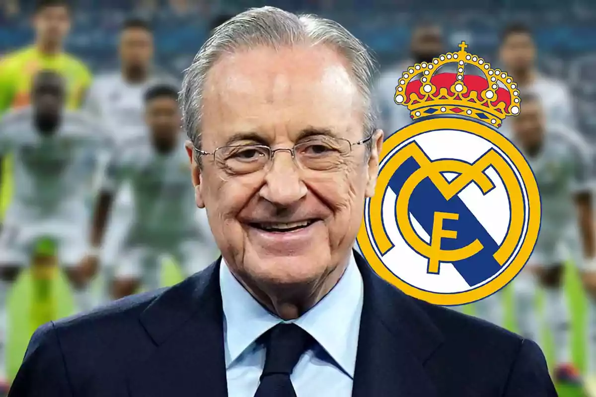 Un hombre mayor con gafas y traje sonríe frente al escudo del Real Madrid, con jugadores desenfocados al fondo.