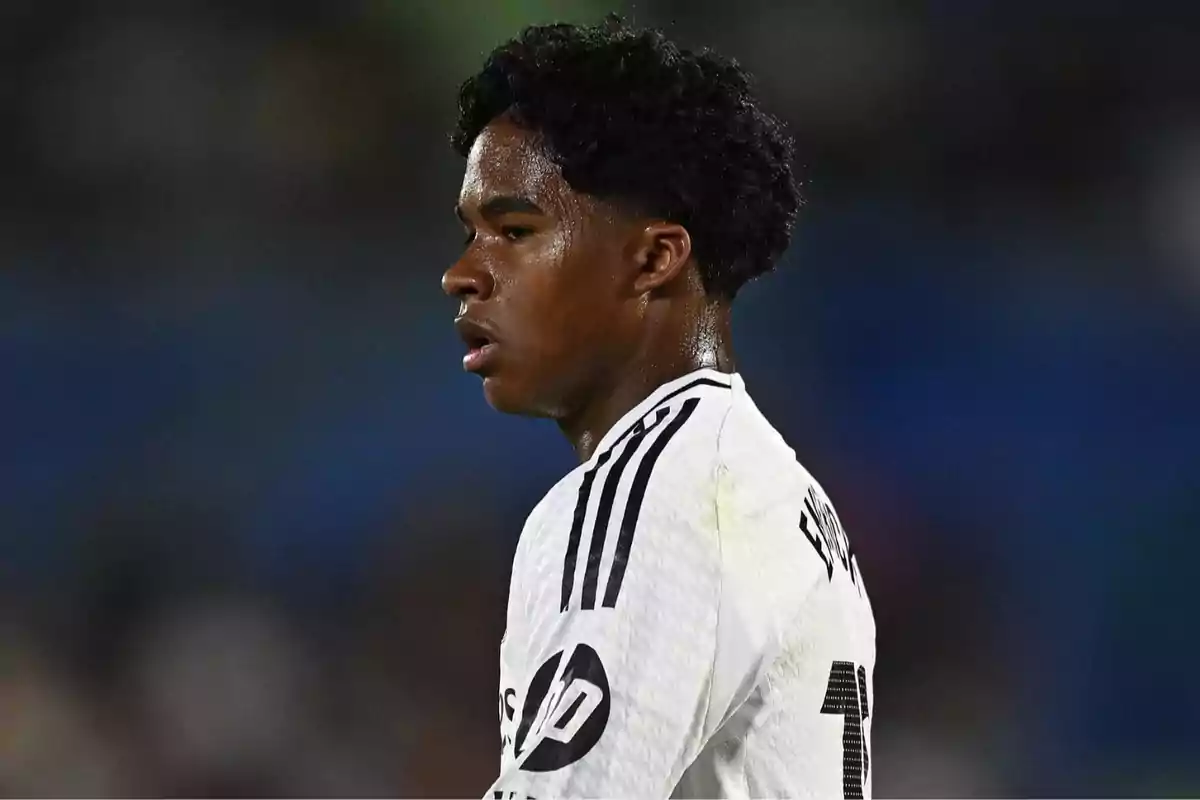 A player in a black and white uniform is on the field, looking to the right, with a sweaty and focused face. A player in a black and white uniform is on the field, looking to the right, with a sweaty and focused face.