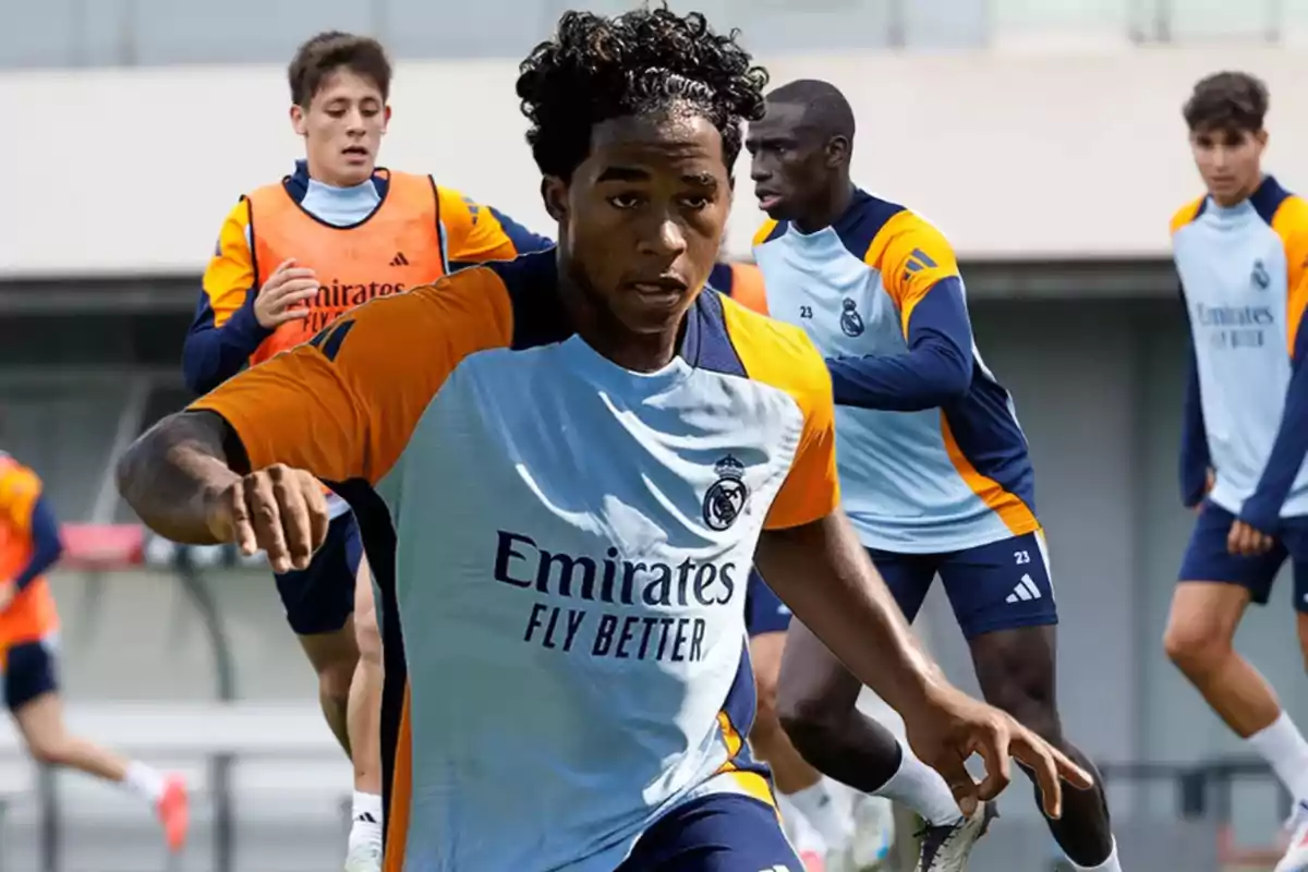 Jugadores de fútbol entrenando con uniformes del Real Madrid en un campo de entrenamiento.