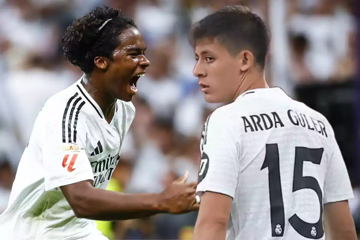 Dos jugadores de fútbol con camisetas blancas celebran en el campo.