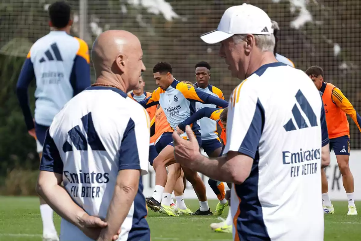 Entrenadores y jugadores de fútbol en un campo de entrenamiento.