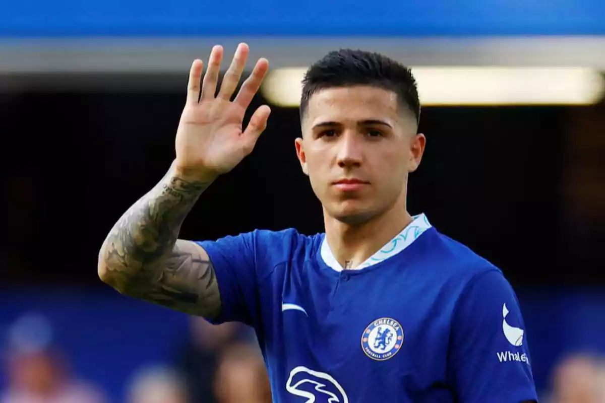 A player in a blue uniform raises his hand in greeting. A player in a blue uniform raises his hand in greeting.