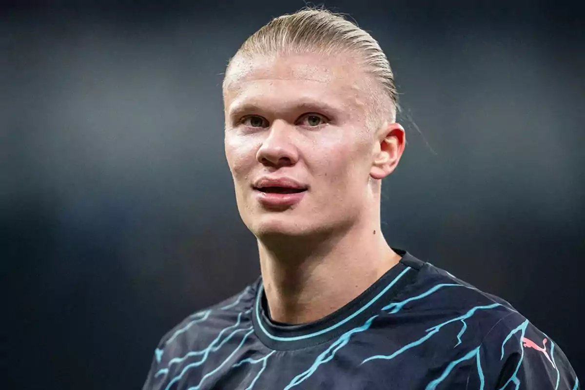 A player with slicked-back blonde hair is wearing a black sports jersey with light blue details. A player with slicked-back blonde hair is wearing a black sports jersey with light blue details.