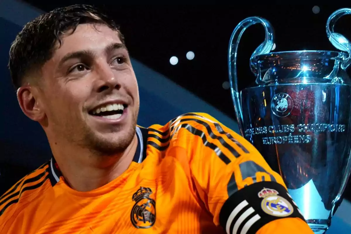 Un jugador de fútbol con la camiseta del Real Madrid sonríe junto a un trofeo de la UEFA Champions League.