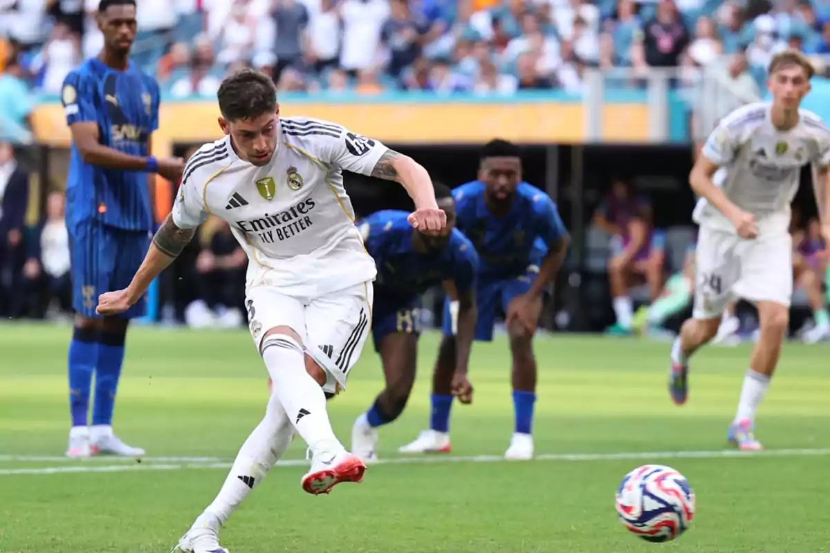 Real Madrid player taking a penalty kick during a match while other players watch from the background Real Madrid player taking a penalty kick during a match while other players watch from the background