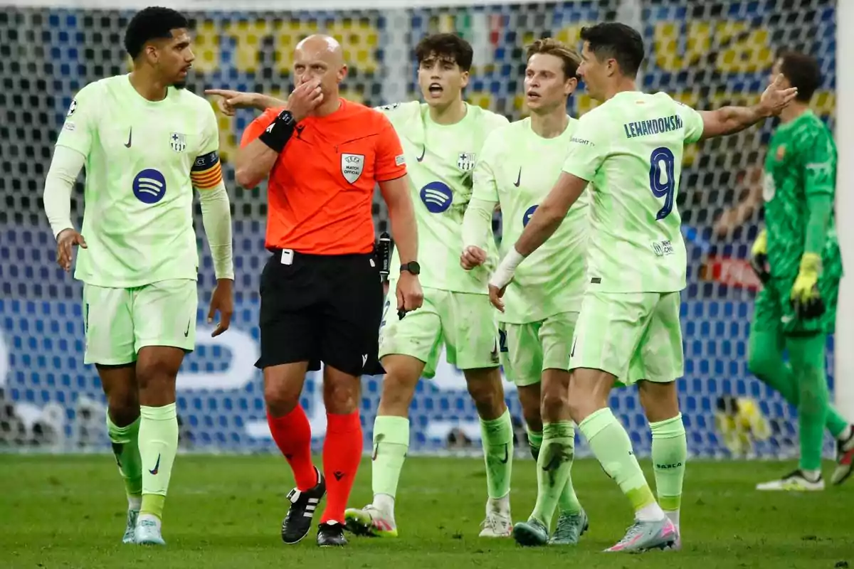 A group of players in green uniforms argues with a referee dressed in orange on the playing field. A group of players in green uniforms argues with a referee dressed in orange on the playing field.