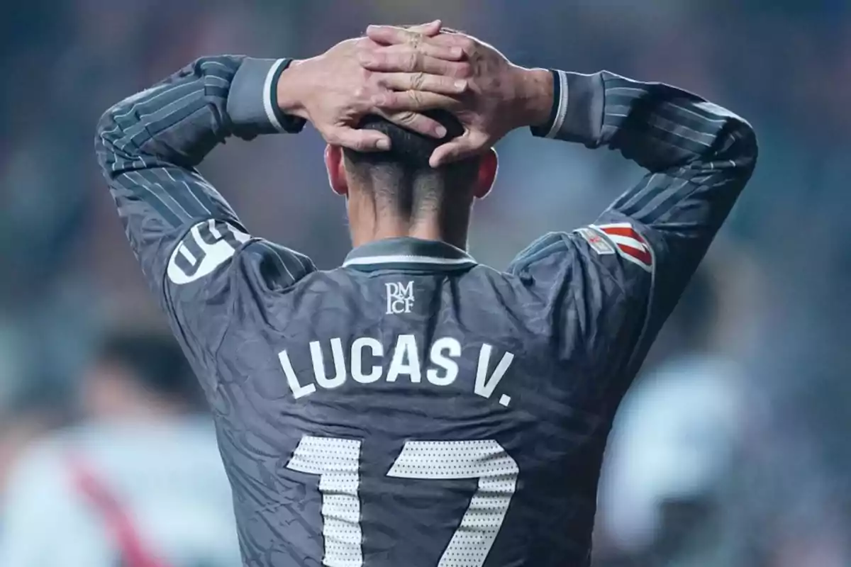 Jugador de fútbol con las manos en la cabeza, vistiendo una camiseta gris con el número 17 y el nombre Jugador de fútbol con las manos en la cabeza, vistiendo una camiseta gris con el número 17 y el nombre