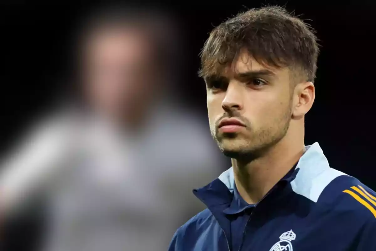 Un jugador de fútbol con chaqueta del Real Madrid mira hacia el frente con expresión seria.